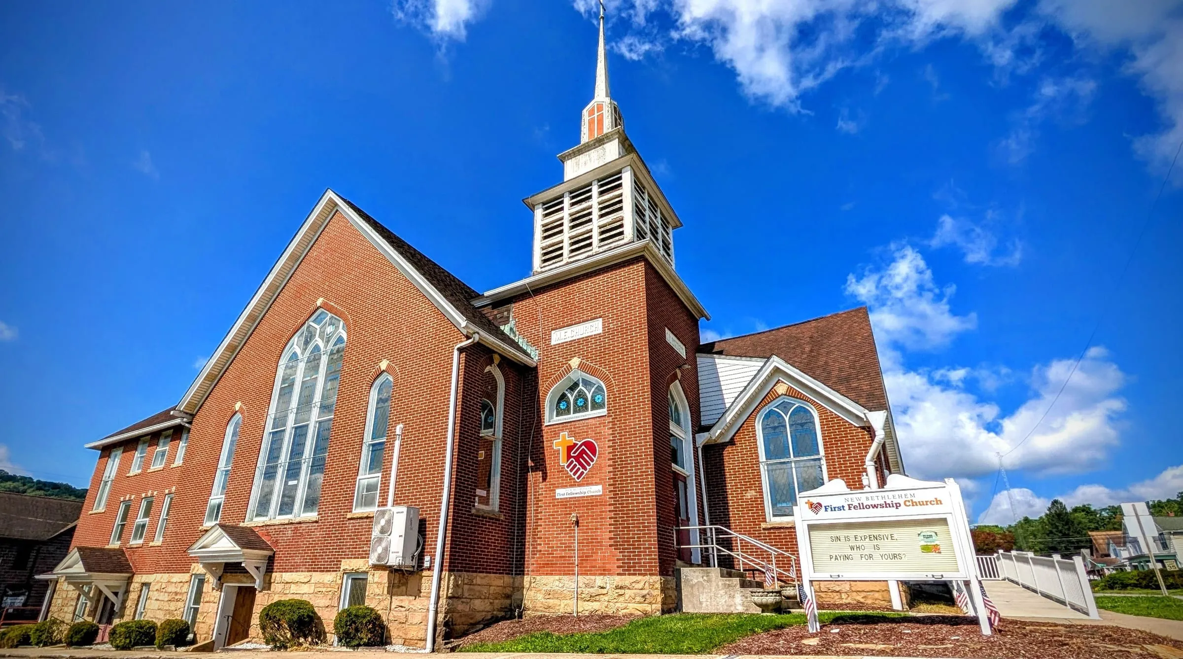 The red brick church building at 234 Penn Street under a blue sky