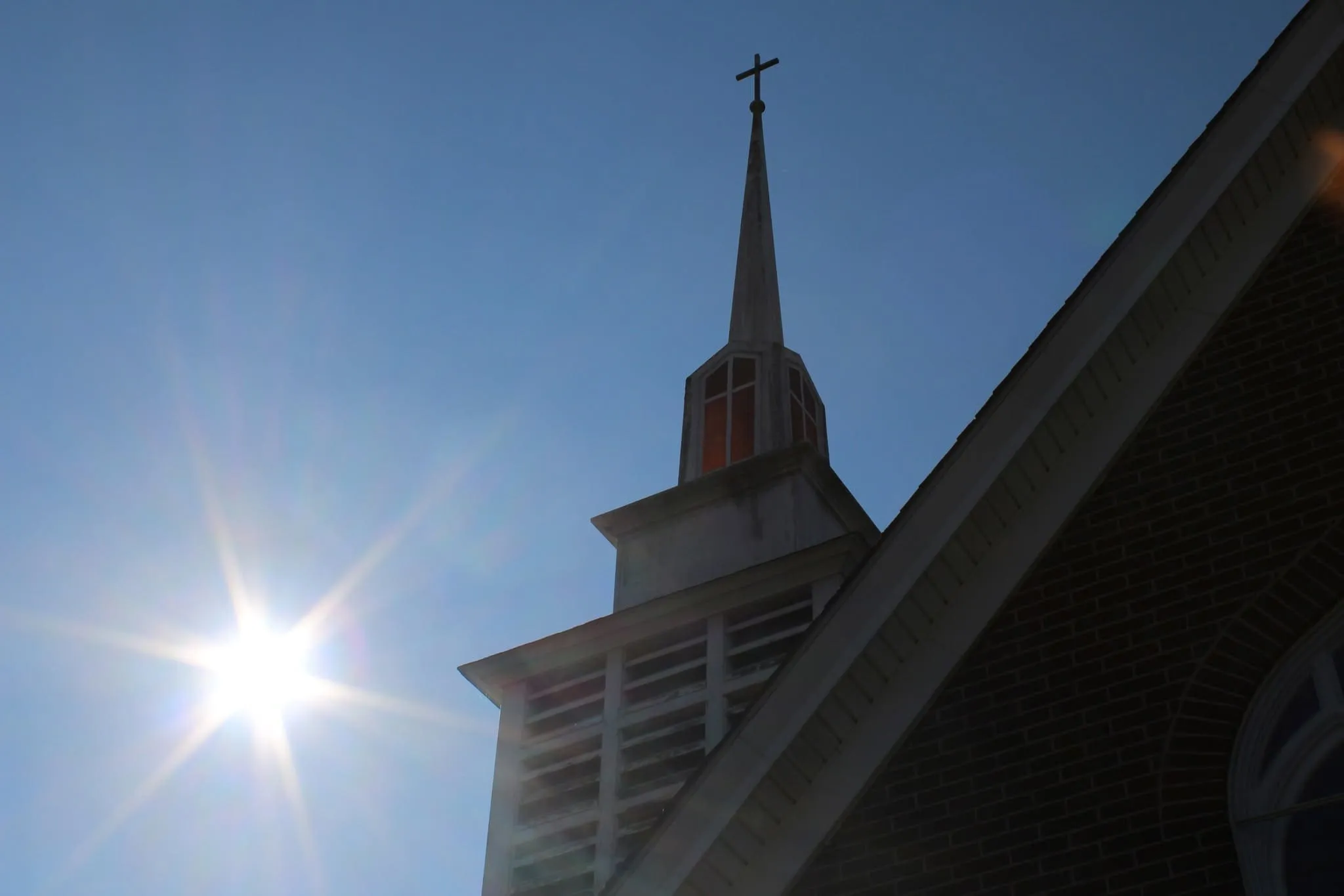 The church steeple against a bright sky